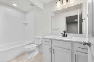 Full bathroom with shower / bath combination, vanity, tile patterned floors, and toilet