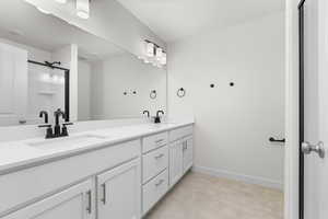 Bathroom featuring dual vanity and an enclosed shower