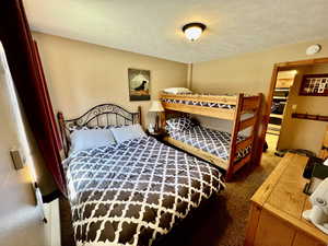 Carpeted bedroom featuring a textured ceiling