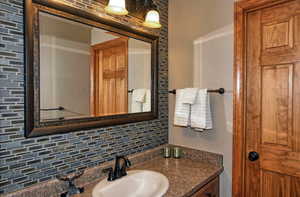 Bathroom with vanity and decorative backsplash