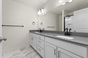 Bathroom featuring tile patterned flooring and double sink vanity