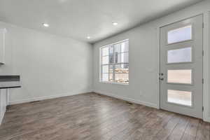 Interior space with a textured ceiling and hardwood / wood-style floors