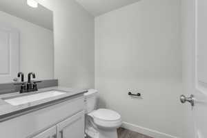 Bathroom featuring vanity, toilet, and wood-type flooring