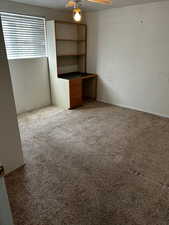 Interior space featuring ceiling fan, light carpet, and a textured ceiling