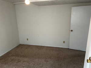 Spare room featuring carpet floors and a textured ceiling