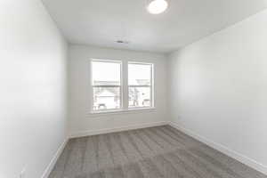 Carpeted spare room featuring a textured ceiling