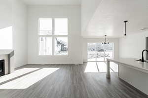 Unfurnished living room with sink, a fireplace, dark hardwood / wood-style floors, and a textured ceiling