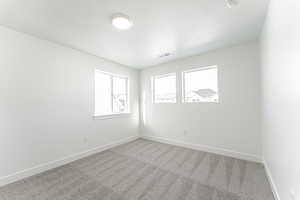 Carpeted empty room featuring a textured ceiling