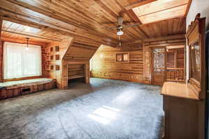 Primary bedroom with carpet, wood ceiling, and ceiling fan