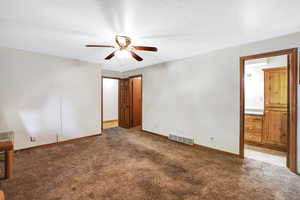 Unfurnished bedroom featuring carpet, connected bathroom, and ceiling fan