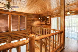 Hall with hardwood / wood-style flooring, wood ceiling, and rustic walls