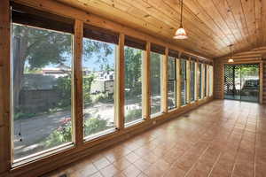 Unfurnished sunroom with wood ceiling and large windows