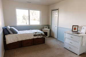 Carpeted bedroom with a closet