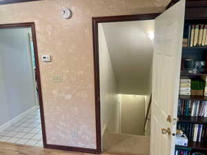 Stairway leading to basement featuring tile patterned flooring