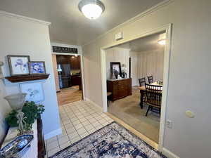 Entry Hallway featuring light colored carpet and crown molding