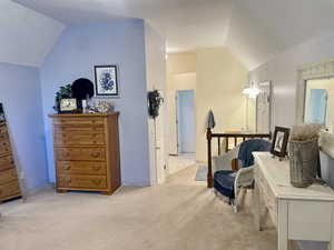 Primary Bedroom sitting room featuring light carpet and vaulted ceiling