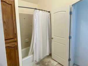 Primary Bathroom featuring tile patterned floors and shower / bathtub combination with curtain