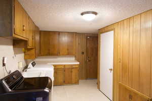 Washroom with cabinets, a textured ceiling,