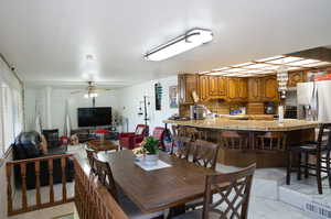 Dining room with light tile patterned flooring and ceiling fan