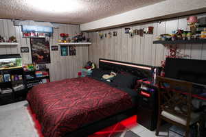 Bedroom with light tile patterned floors and a textured ceiling