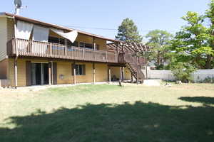 Back of house with a yard and a deck