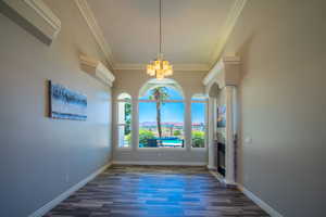 Front LR with a notable chandelier, ornate columns, dark hardwood / wood-style flooring, and ornamental molding