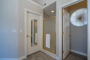 Bathroom featuring hardwood / wood-style flooring and a shower with door