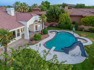 View of pool with a patio, a diving board, and a water slide