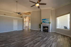 Unfurnished living room featuring a fireplace, ceiling fan, and a healthy amount of sunlight