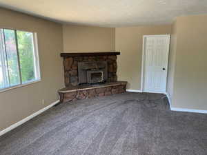 Unfurnished living room with a fireplace and carpet floors