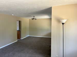 Carpeted empty room with a textured ceiling