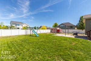 Backyard. View of grass area, patio, and chicken coop