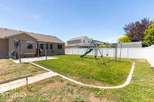 Backyard. View of grass area, patio, and playset