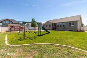 Backyard. View of grass area, patio, and chicken coop