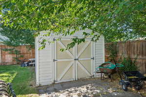 View of outbuilding featuring a lawn