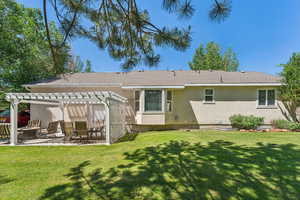 Back of house with a patio, a yard, and a pergola