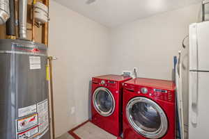 Washroom with washer and clothes dryer and secured water heater