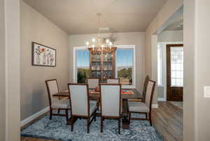 Dining room with an inviting chandelier and hardwood / wood-style flooring