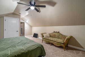 Bedroom with ceiling fan, carpet floors, and vaulted ceiling