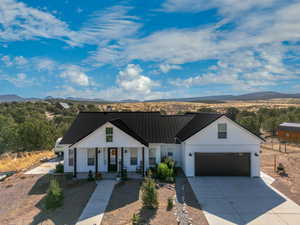 Modern farmhouse style home featuring a garage, a mountain view, and covered porch