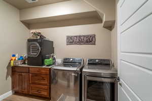 Laundry area featuring light wood-type flooring and separate washer and dryer