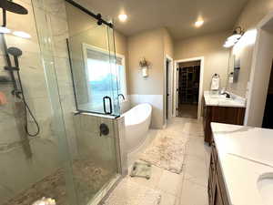 Bathroom featuring tile walls, vanity, and separate shower and tub