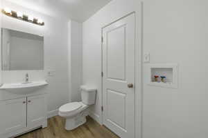 Bathroom featuring vanity, toilet, and hardwood / wood-style floors