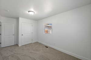 Unfurnished bedroom featuring light carpet