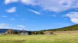 View of property's community with a lawn, a mountain view, and a rural view