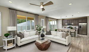 Living room with LVT flooring, and a wealth of natural light.Materials and color features selected may vary; these are pictures of a model home.