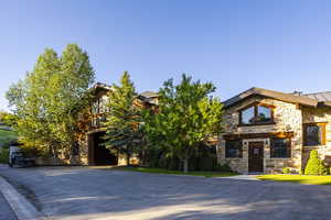 View of front facade featuring stone siding, a standing seam roof, and metal roof