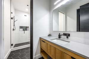Full bath featuring a shower stall, vanity, tile patterned flooring, baseboards, and recessed lighting