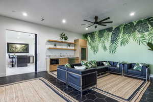 Living room with bar, recessed lighting, a ceiling fan, tile patterned floors, and baseboards