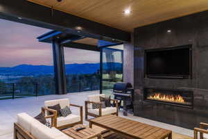 Living area with expansive windows, a fireplace, and wood ceiling